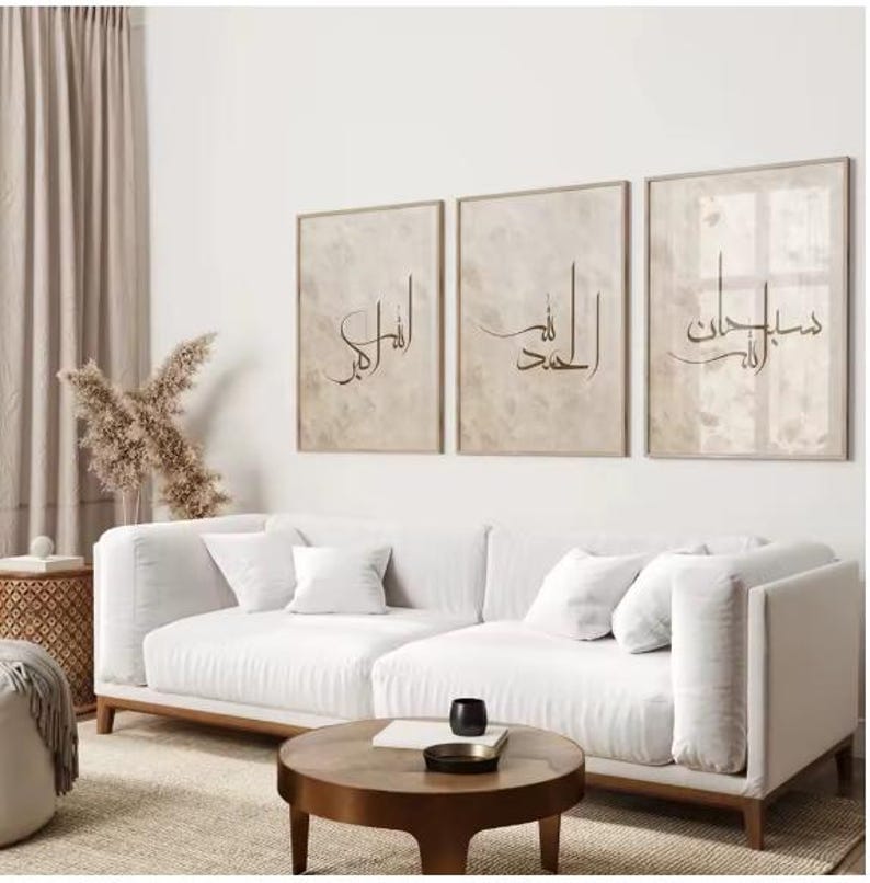 Modern living room with a white sofa, wooden coffee table, and three framed artworks on the wall.