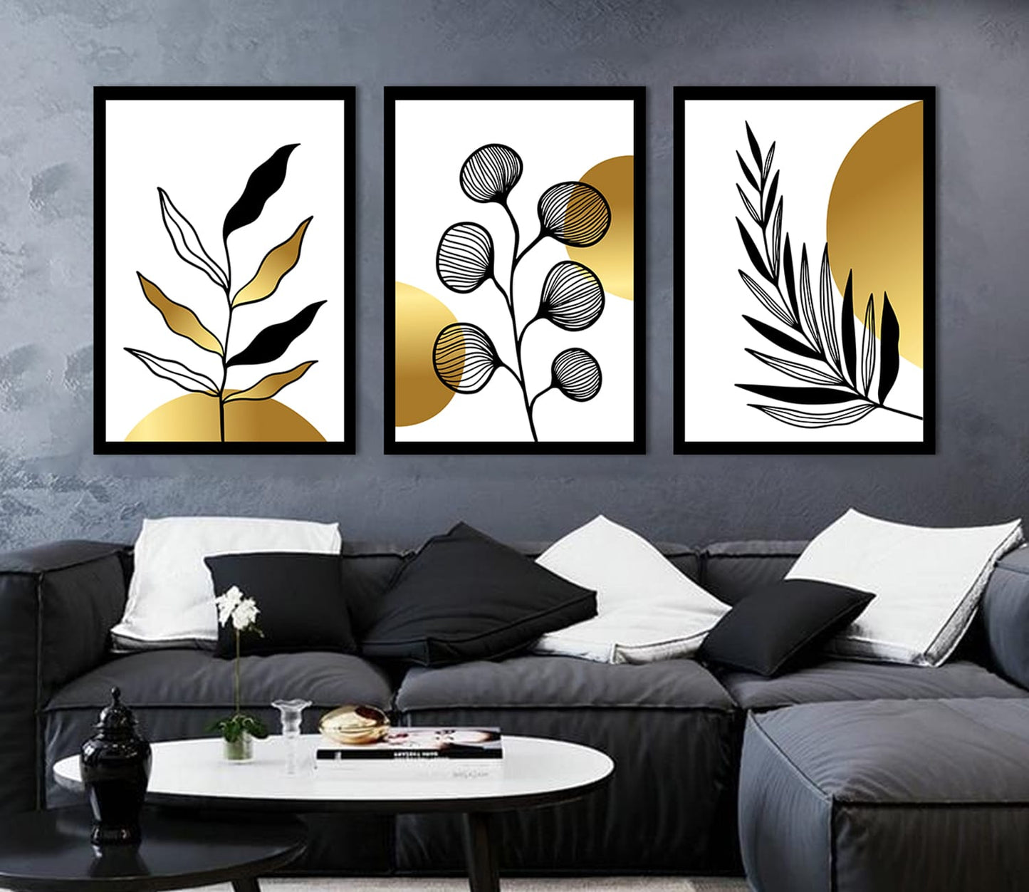 A luxurious set of three framed black and gold botanical wall art prints showcasing delicate golden leaves and floral patterns on a dark black background, adding a touch of elegance to modern home decor.