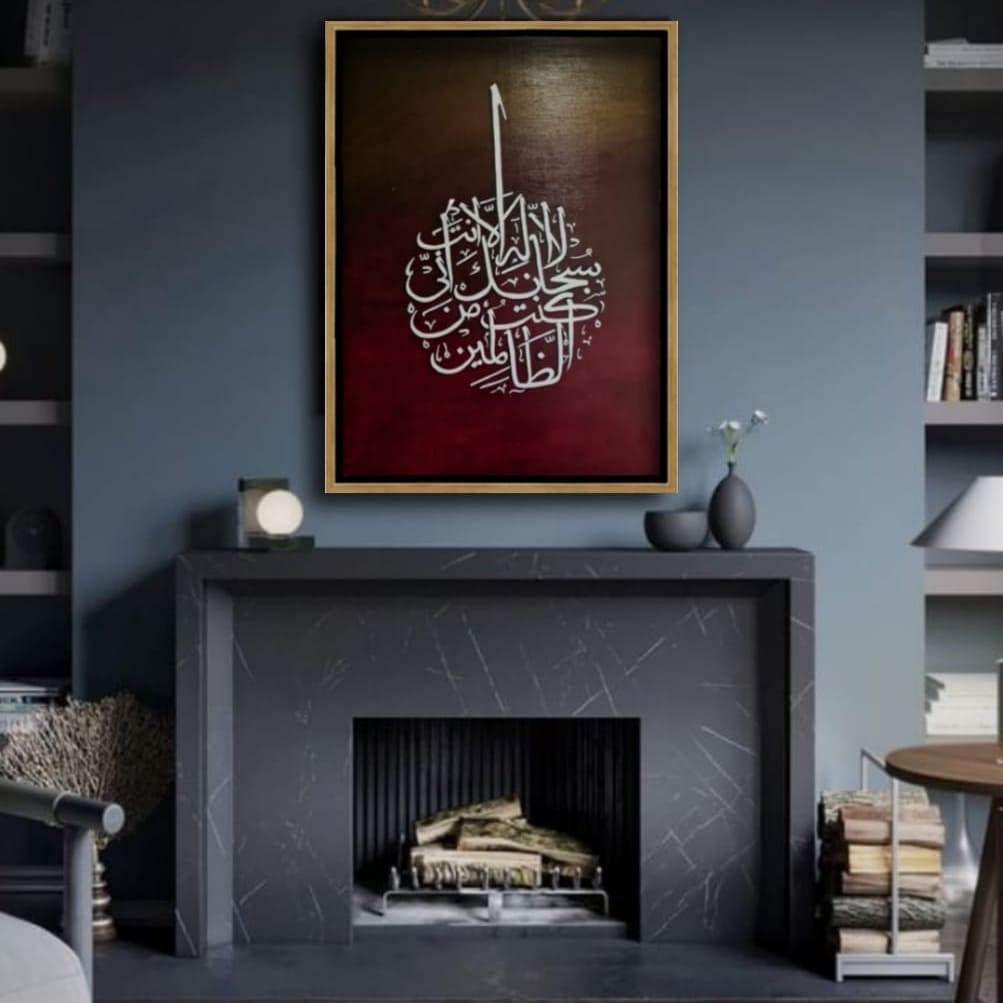 Islamic calligraphy wall frame featuring la ilaha anta subhanaka inni kuntu minaz-zalimin, Surah Al-Anbiya (21:87) in white Arabic script against a deep red and black gradient background, enhancing spiritual ambiance in home decor.