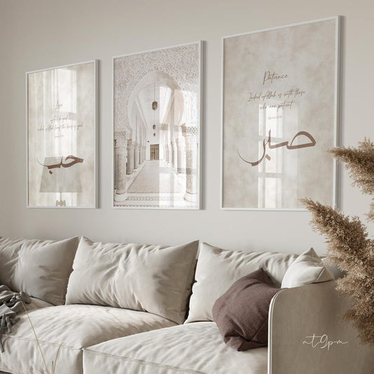 Three framed artworks on a wall above a sofa with decorative pillows.