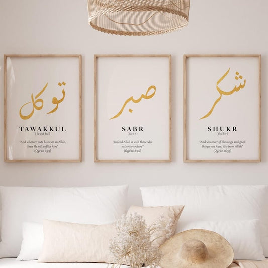 Three framed prints with Arabic calligraphy and English translations on a wall above a bed.